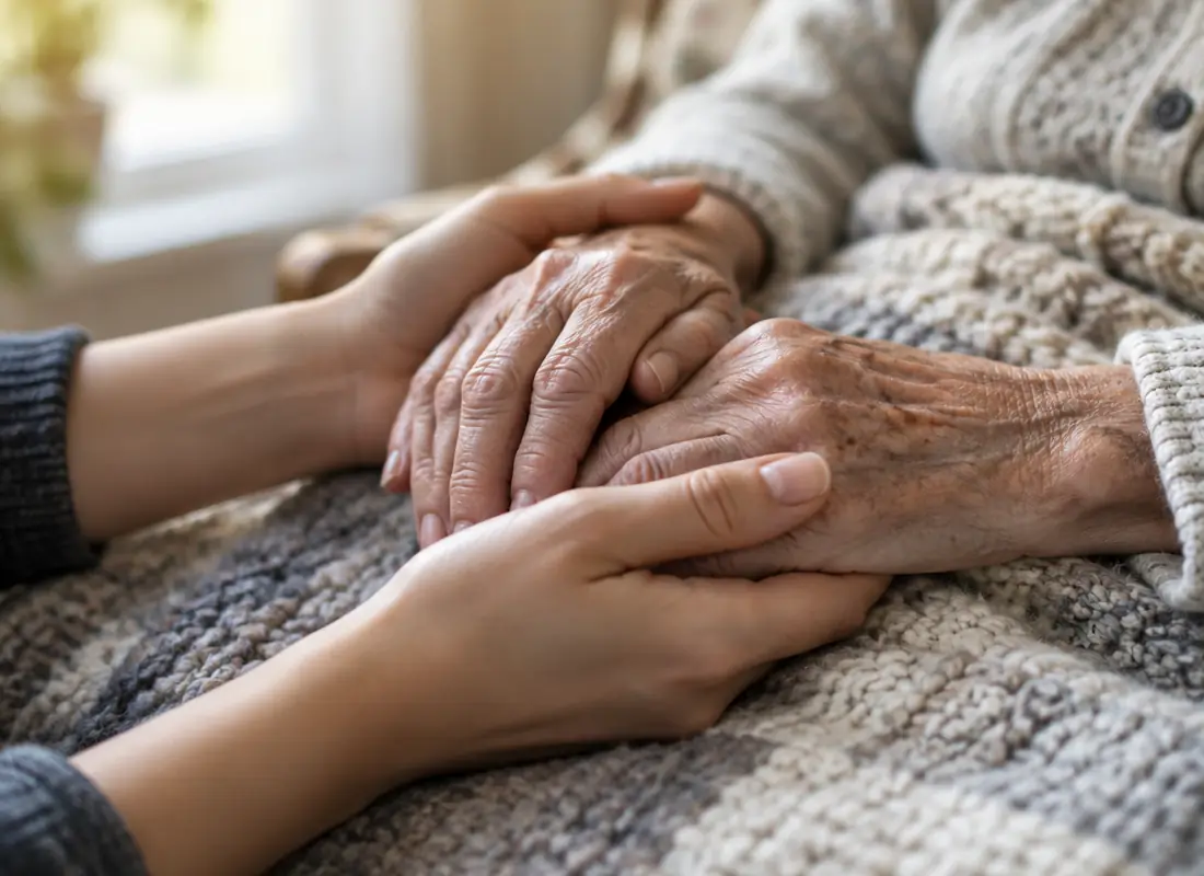 Mani di una persona anziana sostenute da un familiare